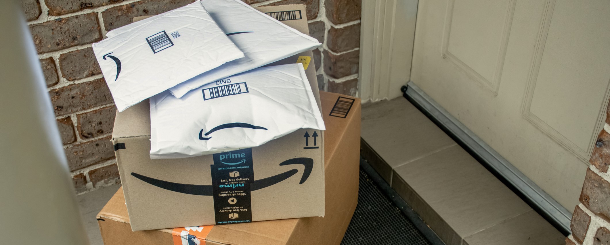 Stack of Amazon packages piled at a doorstep