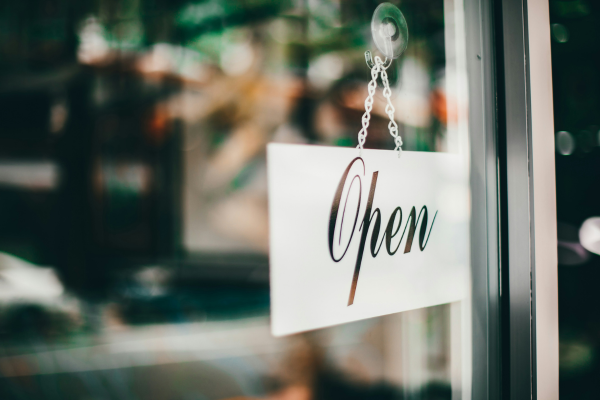 Storefront door with small open sign hanging on front door