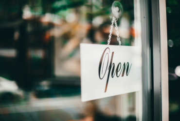 Storefront door with small open sign hanging on front door
