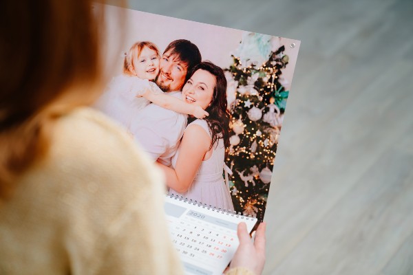 a woman holding a calendar with family photos