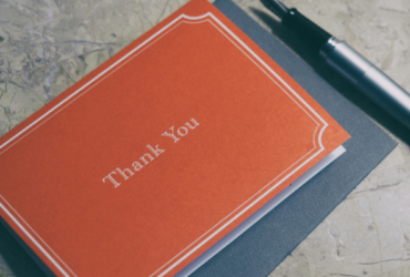 A small red folded card that says "Thank You" on the front