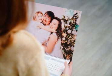 a woman holding a calendar with family photos