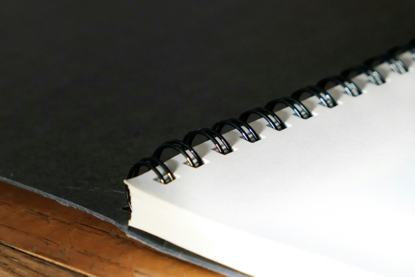 A stack of blank white papers that have been coil bound