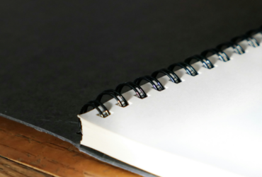 A stack of blank white papers that have been coil bound