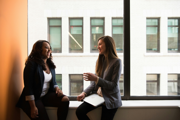 Two people sitting beside a window in an office building.