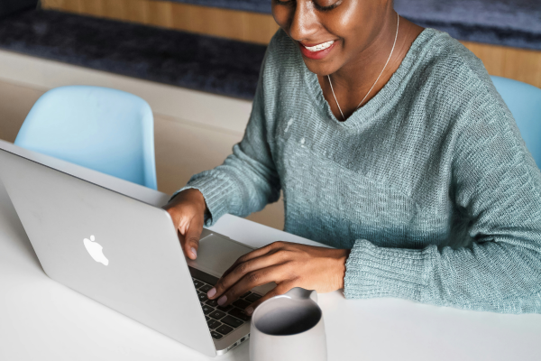 Woman sitting at desk typing on laptop computer