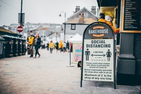 A social distancing sign outside a cafe