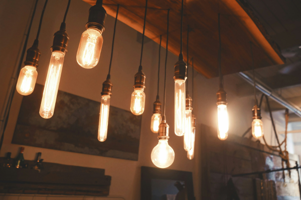 Different sized light bulbs hanging from a fixture inside of a store